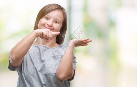 在孤立的背景下患有唐氏综合症的年轻成年女在用手展示并用手指点时对着镜头感图片