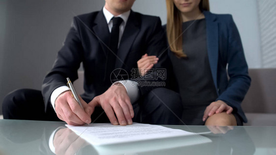 签署商业合同购买或出售财产保险的年轻夫妇图片