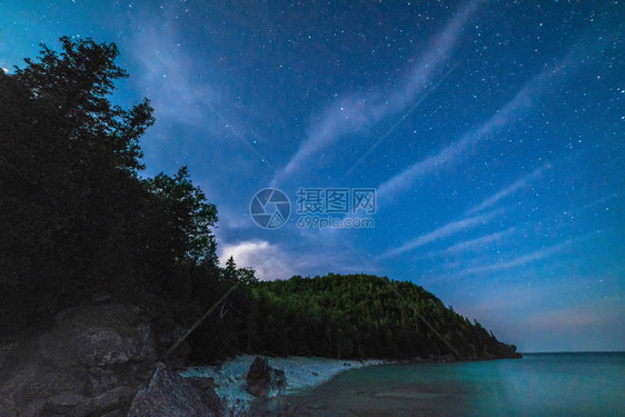 夜晚在格鲁吉亚湾湖岸边的银状冰雪和星空图片