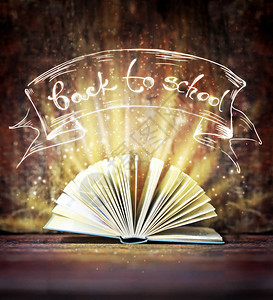 木桌上的魔法闪亮书背景图片