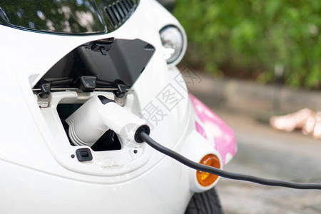 带上电池充电器与电动汽车连接将电动汽车放入车内清洁能源不会污染空气节能理图片