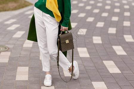 温暖的绿色polto白色运动鞋黄色围巾绿色夹克一个棕色图片