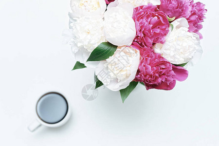 白桌背景有一杯咖啡和白花及粉红小马花的工作场所平图片