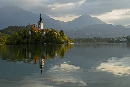 美丽的山湖布莱德位于岛上的圣母升天朝圣教堂背景中的山脉斯洛文尼亚图片