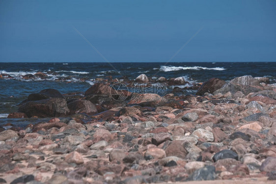 白天的岩石海滩和湛蓝的天空图片