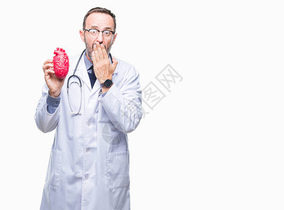 中年老心脏病专家医生男子将心脏放在孤立的背景上图片
