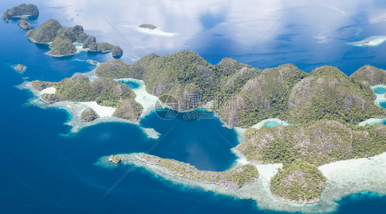 壮观的石灰岩岛屿从印度尼西亚四王群岛美丽的海景中升起这个偏远地区因其丰富的海洋生物多样而被称为珊图片