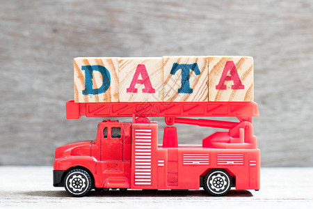 玩具消防梯式卡车在木材背景的文字数据中图片