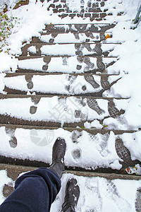 冬天有滑倒在雪覆盖的楼梯上的危险一个女人想从滑坡的楼梯下去图片