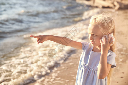 可爱的小女孩沙滩上的贝壳图片