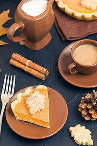 棕色盘子中的牛奶与秋黄叶的黑色背景相配图片