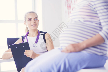 在诊所检查孕妇的年轻女医生图片