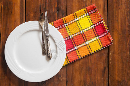 黑色木制桌子上装有餐具和彩色餐巾的压实桌布文字空图片