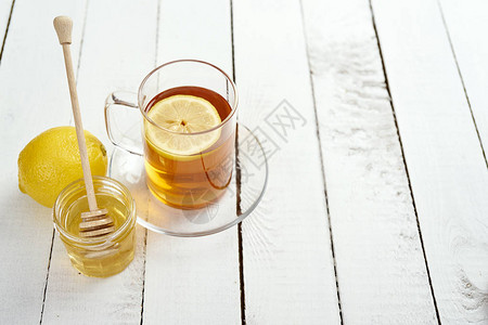 茶杯加蜂蜜和美味的柠檬茶在图片