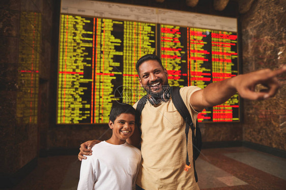 只是看一名积极的印度教男子和他的儿子站在火车站检查其图片