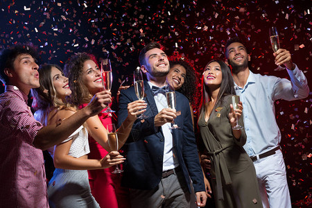 不同的人在夜总会庆祝新年举着香槟长图片
