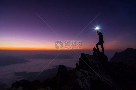 登山者或背包者在日落时站在岩石山峰上图片