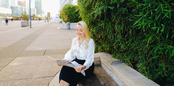 大众传媒和商业服装概念美丽的金发女子在绿色植物附近休息图片