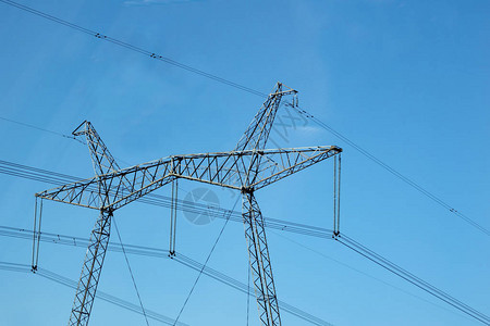 电网和电线杆反对蓝天背景图片