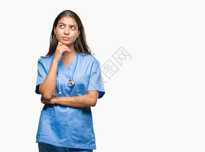 年轻的阿拉伯医生外科医生女人在孤立的背景下用手托着下巴思考问题图片