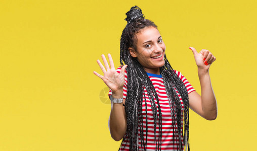年轻的辫子头发的非洲裔美国女孩在孤立的背景下展示并用六号手指向上方图片