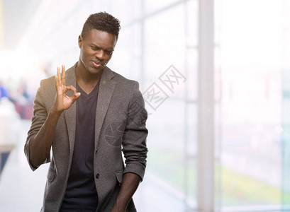 身穿夹克的非洲青年男子用手指签好标志图片
