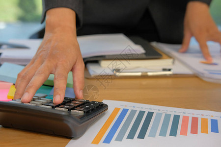 财务顾问在办公室使用计算器商业文件会计做会计和算收入和预算簿记员进行计算金图片