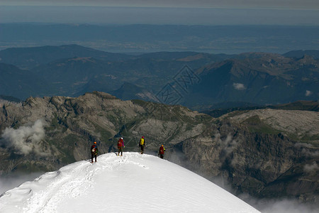 用绳子绑着冰斧和头盔的雪地登山者被绑在山上图片