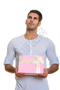 年轻英俊的波斯男子拿着礼物盒却在白种背图片