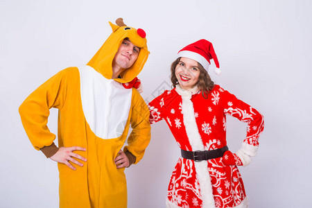 快乐的年轻女子在圣诞老人帽子和鹿狂欢节服装的男人乐趣节日笑话和图片