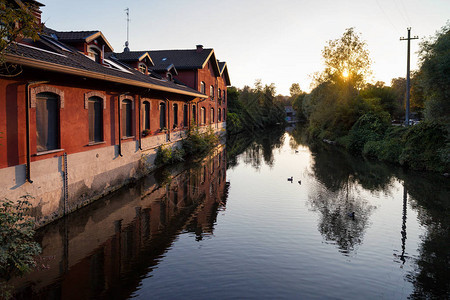 日落时在河床上反射的旧纺织厂图片