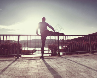 高个子运动员在早上跑步锻炼前热身图片