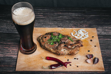 猪肉加调味料和一杯啤酒在木制桌子图片