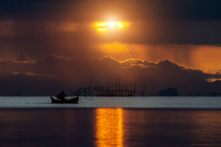 东方明珠剪影湖上最小的剪影渔船日落和雨云背景