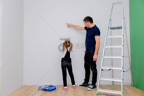 父亲教女儿如何粉刷墙壁图片