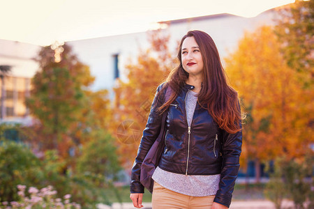 青年女学生户外肖像穿孔着向远方看秋季彩色生活图片