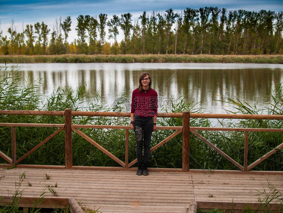 一个少女与木头栏杆在看秋天一图片