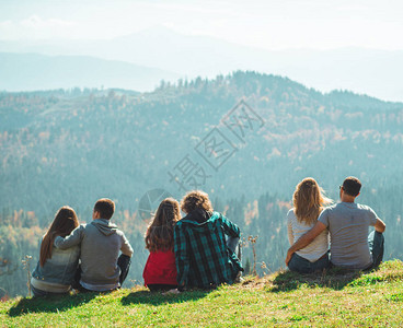 一些情侣旅行者男孩和女孩坐在悬崖上放松山和云鸟瞰爱和旅行快乐情感生活方式概念年轻家庭旅行图片
