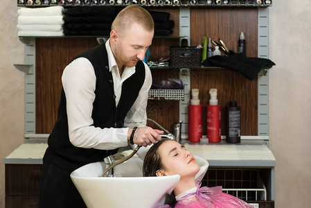 男士美发师洗头客户一位男发型师在美发工作室用淋浴给女图片
