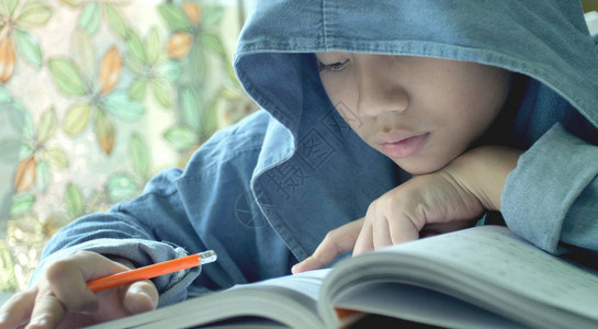 亚洲孩子阅读和写作在家做作业在家做庭作图片