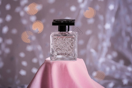 彩色布上的香水瓶背景图片