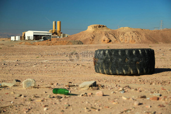 大旧轮胎和垃圾位于约旦亚喀巴市附近的沙漠中背景上的滥用环境沙漠中的黑色轮胎和其他垃图片