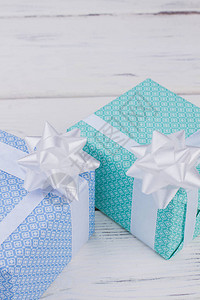 两个颜色的礼物盒放在木制背景上蓝色和绿宝石装饰图片
