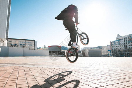 Bmx骑兵在城市风景和阳光的背景下图片