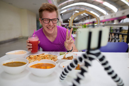 在曼谷市餐厅享受印度美食的年轻英俊旅游男子的肖像图片