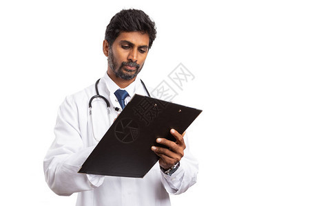 印度男医生在剪贴板上专注和记笔录白图片