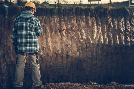 黄色硬帽公司地面工程监督员使用对讲机呼叫其他工人建筑工地监督局的图片