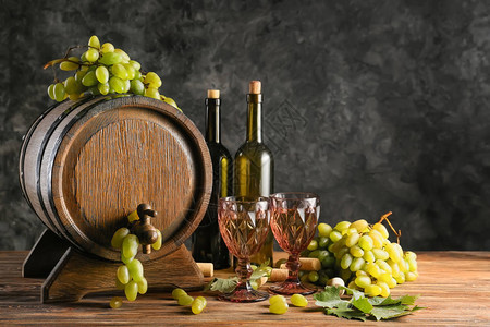 木板上装有酒和成熟葡萄的面包图片