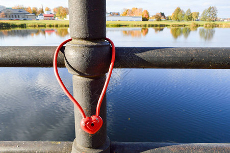 红谷仓锁以心脏的形状挂在一座桥的栏杆上婚礼传统是把永久爱图片