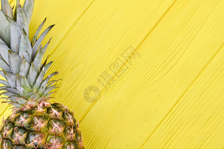 木背景上的新鲜菠萝彩色木制背景上的绿色多汁菠萝果实美图片